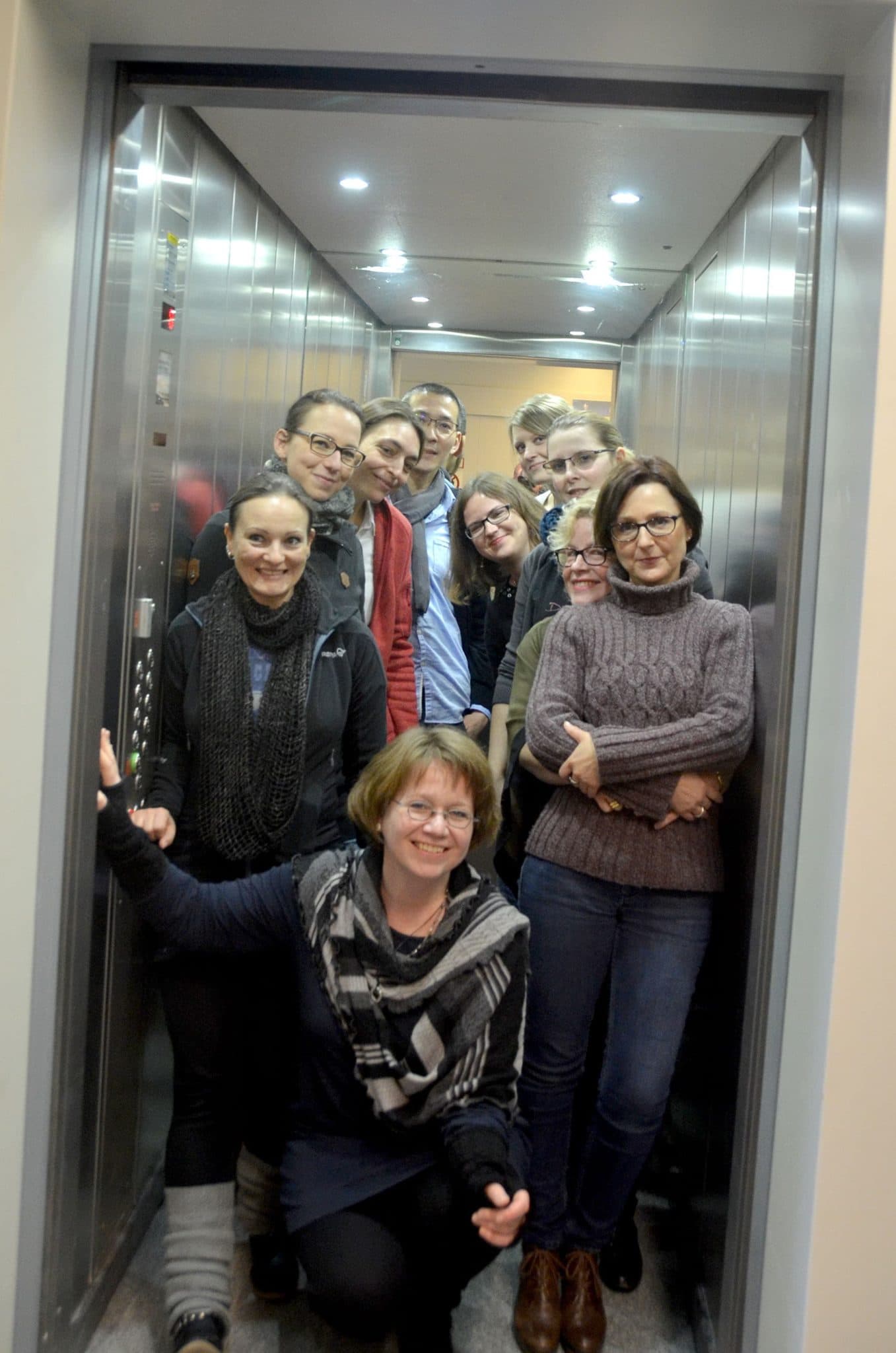 Studierende und Dozenten in einem Aufzug