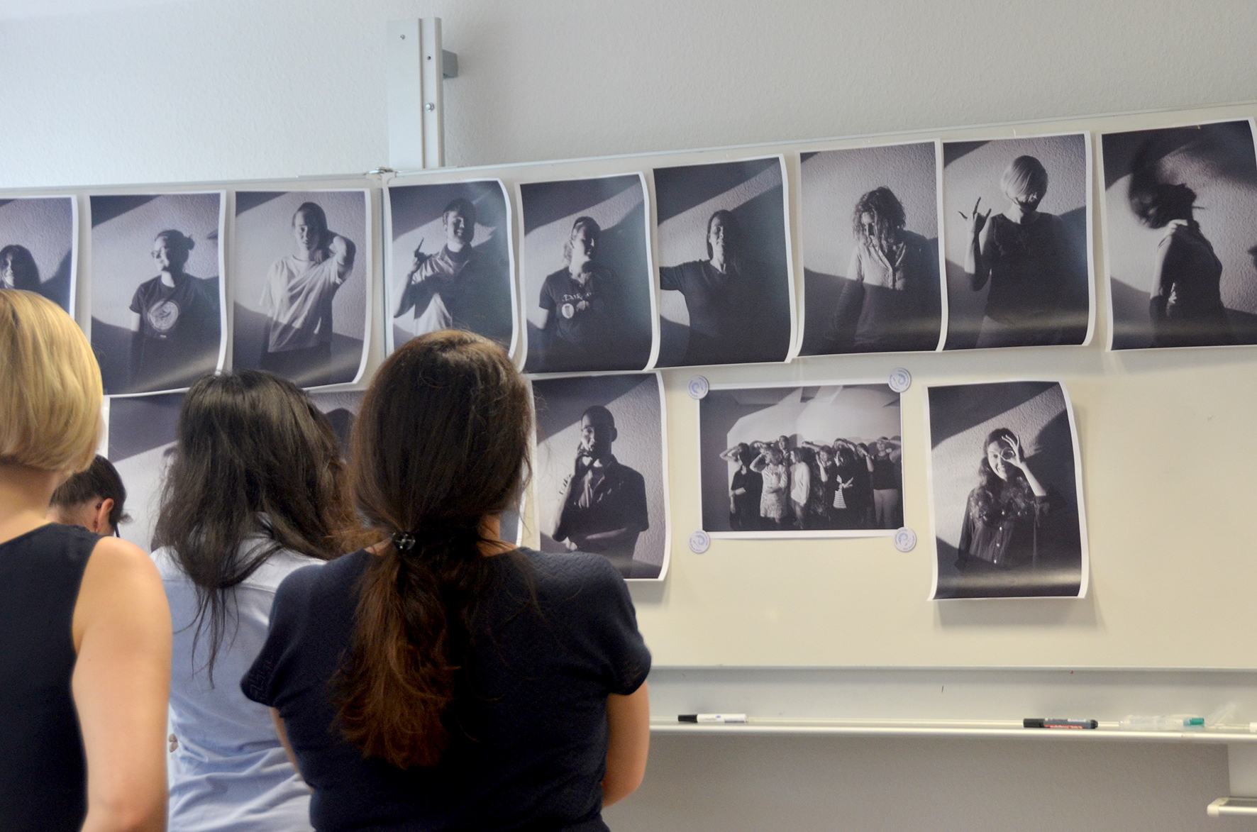 Studierende betrachten schwarz/weiß Fotografien