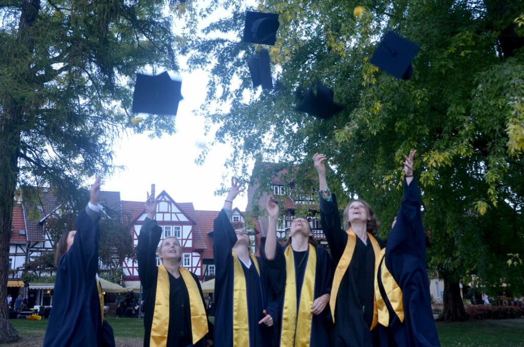 Absolventen werfen Hüte in die Luft