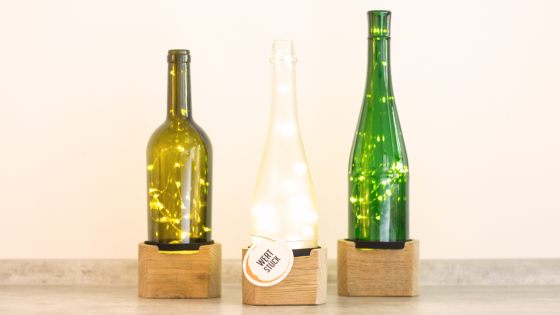 Weinflaschen mit Lichterkette und Wertstücklabel