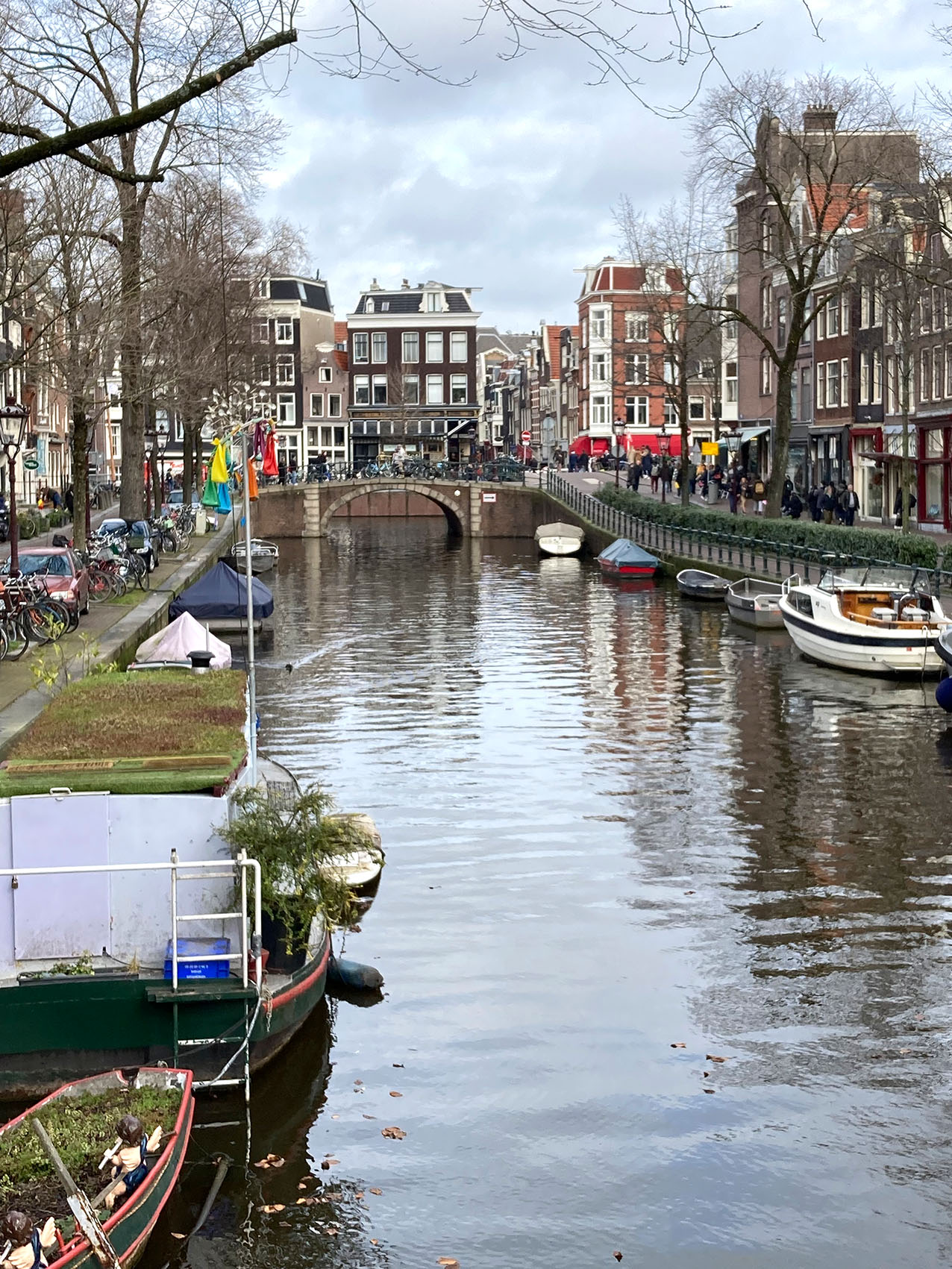 Foto einer Gracht mit Booten und Amsterdamer Häusern